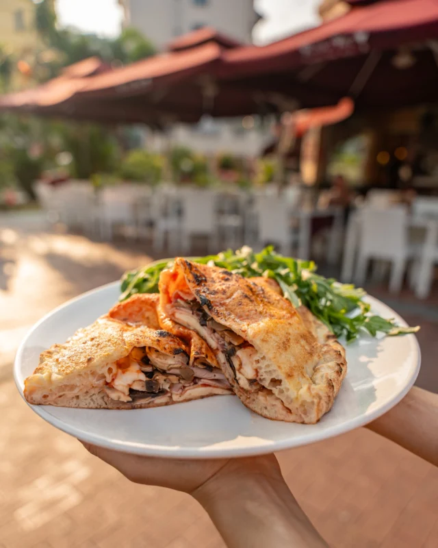 The calzone is essentially a folded pizza, with the dough wrapped around the fillings to keep the cheese, meats and toppings tucked neatly inside.

Our 𝗖𝗮𝗹𝘇𝗼𝗻𝗲 𝗥𝗼𝘀𝘀𝗼 𝗩𝗶𝗻𝗼, has  classic tomato sauce and is PACKED with filling: mozzarella, cooked ham and mushroom, sealed and baked until golden.

Come take a seat, we'll bring it out hot!
.
.
#Calzone #SingaporeRestaurant #ItalianFood #SingaporeFood #SGFoodies